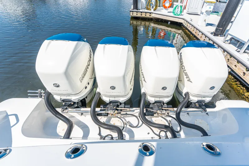 Slide: The Image of Four Mercury outboard engines on a 2019 Boston Whaler 420 Outrage at a dock. - 10