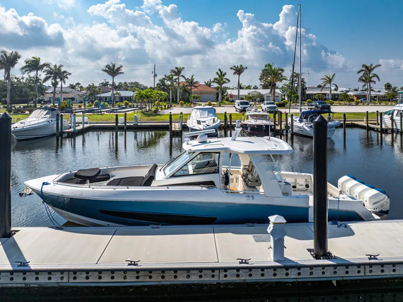 Slide: The Image of 2019 Boston Whaler 420 Outrage docked at a sunny marina with palm trees. - 17