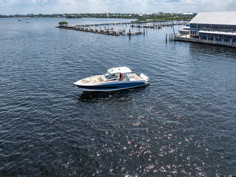 Slide: The Image of 2019 Boston Whaler 420 Outrage cruising near a marina on a sunny day. - 22