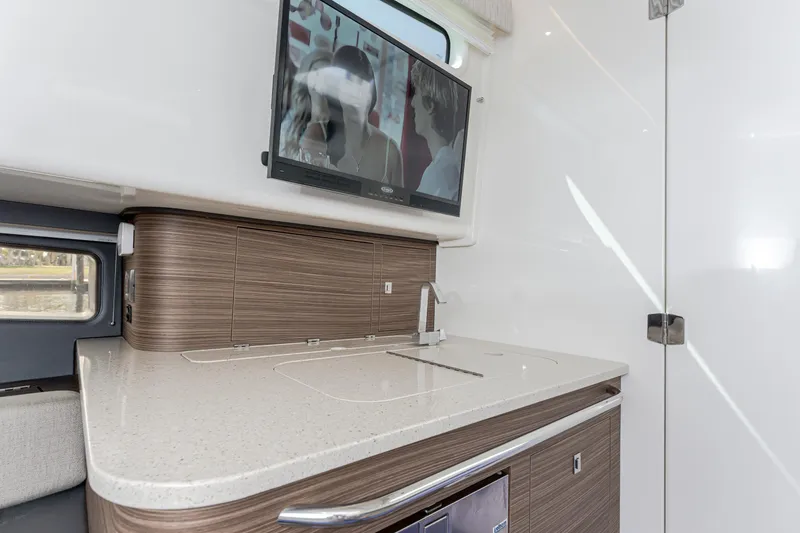 Slide: The Image of 2019 Boston Whaler 420 Outrage interior with modern kitchenette and mounted TV. - 31