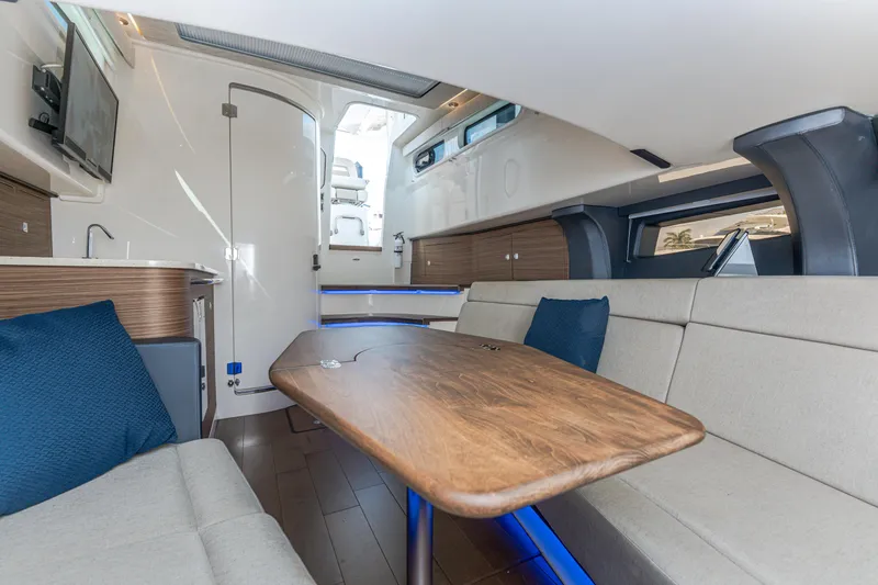 Slide: The Image of 2019 Boston Whaler 420 Outrage interior with modern seating and wooden table. - 37