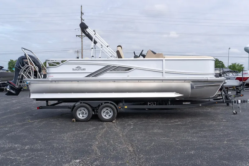 The Image of 2026 SunCatcher Fusion 324SL pontoon boat on trailer, side view in parking lot. - 0