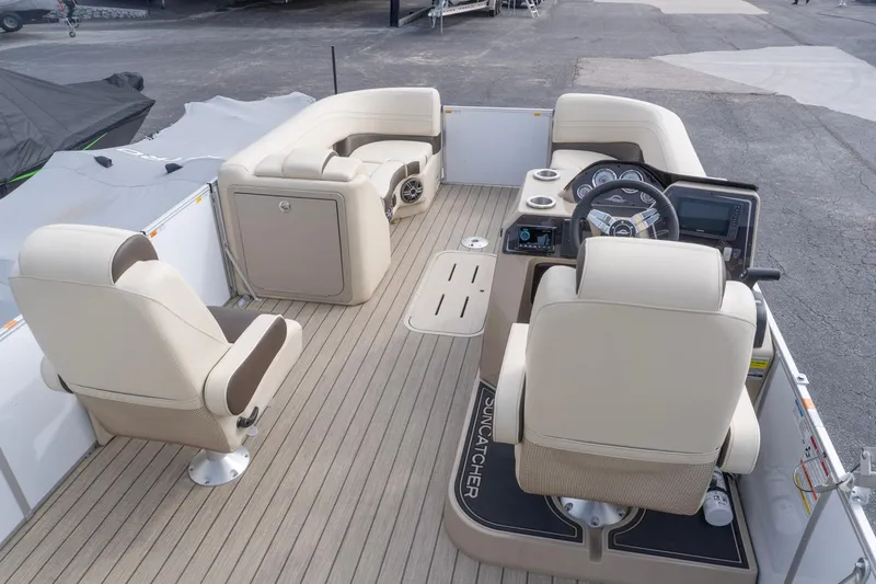 Slide: The Image of 2026 SunCatcher Fusion 324SL boat interior with beige seating and modern dashboard. - 10