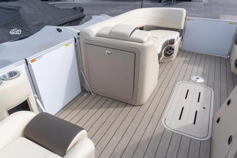 Slide: The Image of 2026 SunCatcher Fusion 324SL boat interior with beige seating and wood-style flooring. - 14