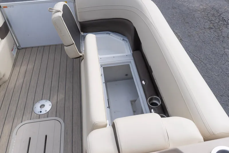 Slide: The Image of SunCatcher Fusion 324SL 2026 boat interior with open storage compartment and beige seating. - 20