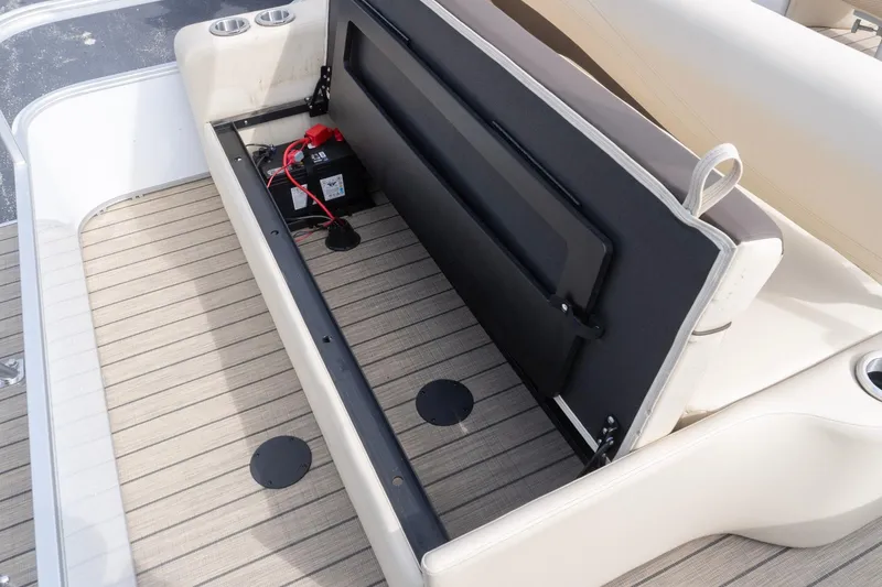 Slide: The Image of Open storage compartment on 2026 SunCatcher Fusion 324SL boat, revealing battery and wiring. - 6