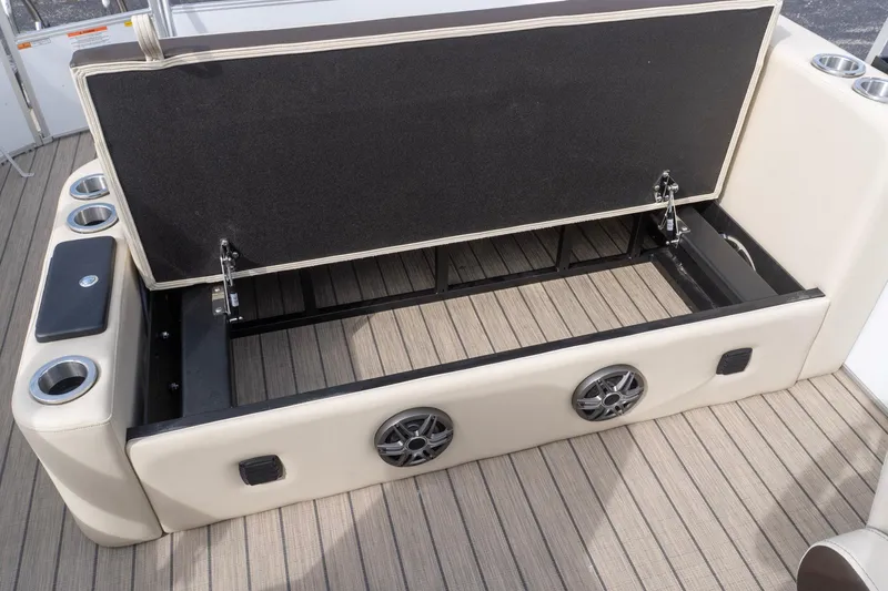 Slide: The Image of 2026 SunCatcher Fusion 324SL boat interior with open storage compartment and cup holders. - 8