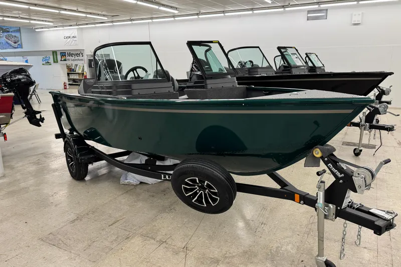 The Image of 2026 Lund 1650 Rebel XL Sport boat displayed in showroom on trailer. - 0
