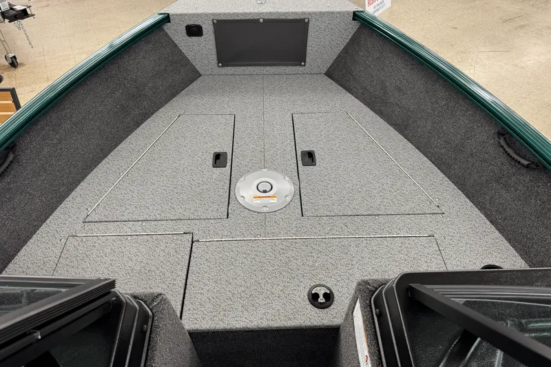 Slide: The Image of 2026 Lund 1650 Rebel XL Sport boat interior with storage compartments and carpeted deck. - 10