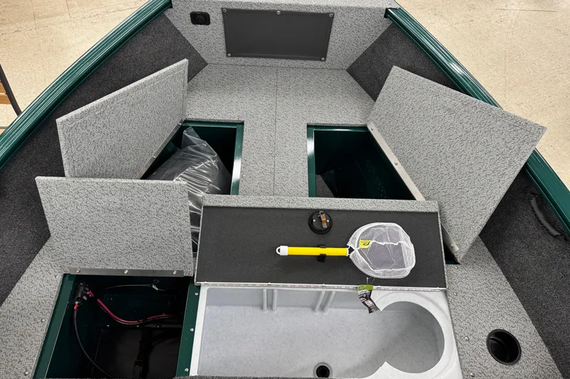Slide: The Image of 2026 Lund 1650 Rebel XL Sport boat interior with storage compartments and fishing net. - 11