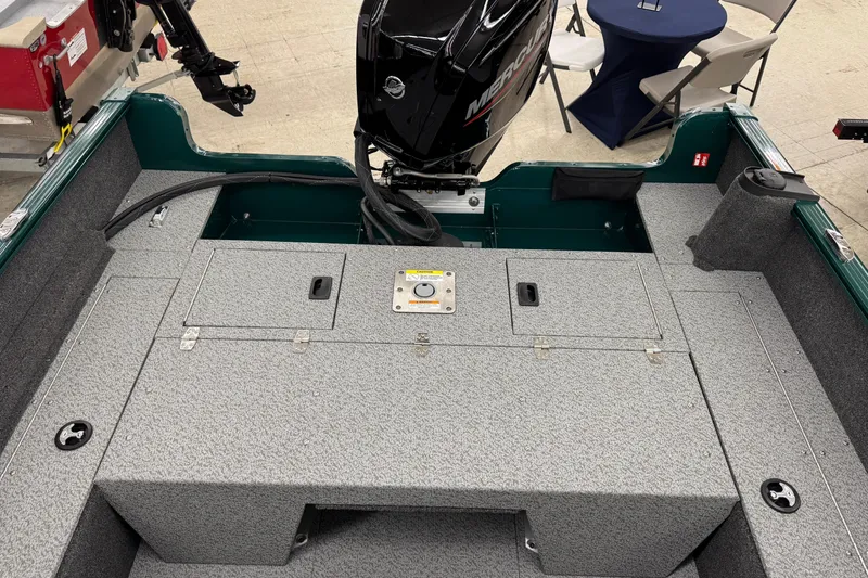 Slide: The Image of 2026 Lund 1650 Rebel XL Sport boat interior with Mercury engine, gray deck, and storage compartments. - 15