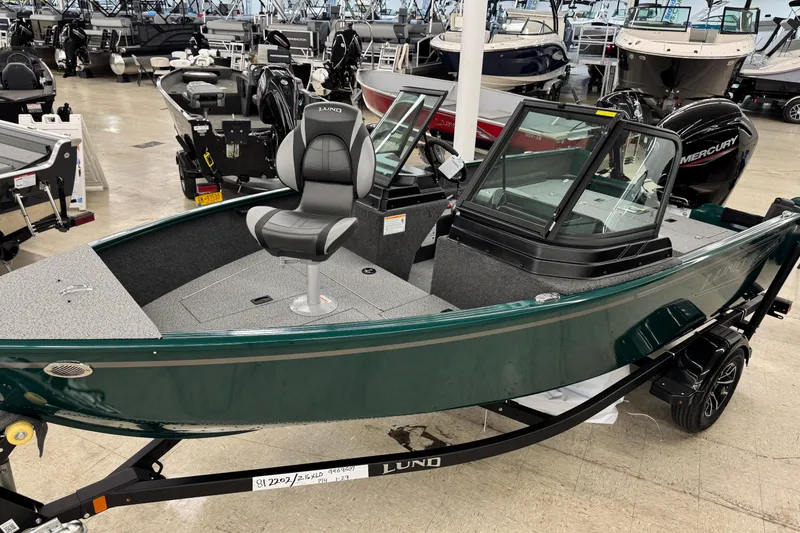 Slide: The Image of 2026 Lund 1650 Rebel XL Sport boat displayed in showroom, featuring sleek design and comfortable seating. - 3