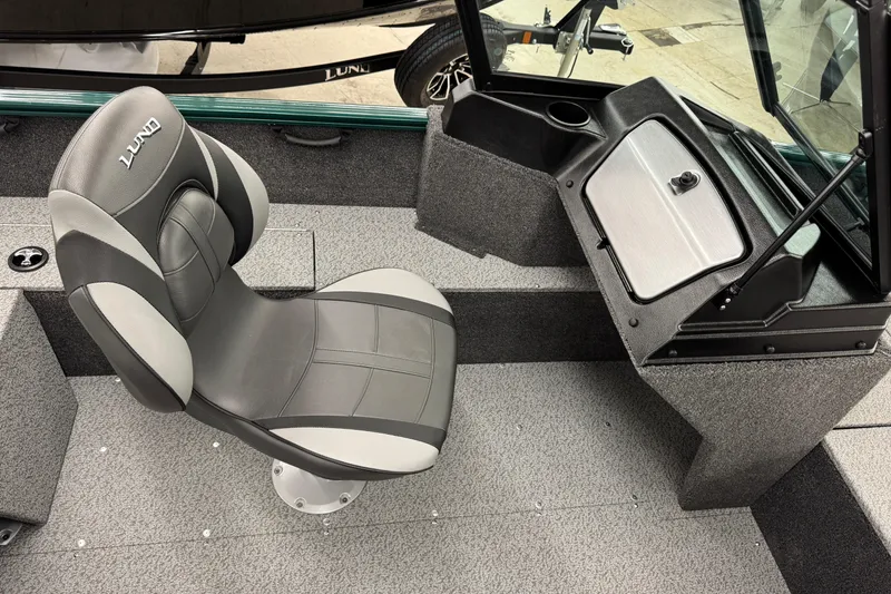 Slide: The Image of 2026 Lund 1650 Rebel XL Sport boat interior with gray seating and storage compartment. - 6