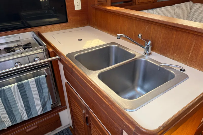 Slide: The Image of 1985 S2 11.0 meter A yacht kitchen with dual sinks and stove. - 21