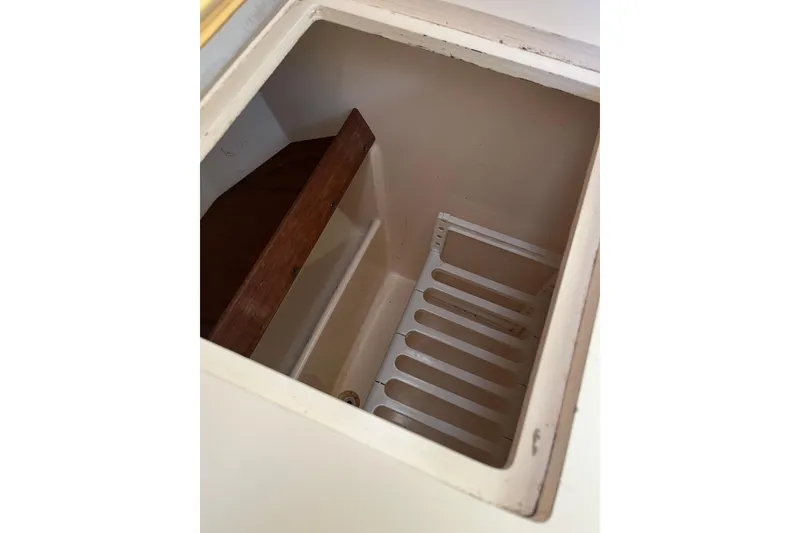 Slide: The Image of Storage compartment inside 1985 S2 11.0 meter A sailboat, featuring wooden and metal shelving. - 23