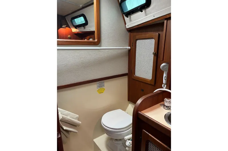 Slide: The Image of 1985 S2 11.0 meter A yacht bathroom with wooden cabinetry and compact toilet. - 26