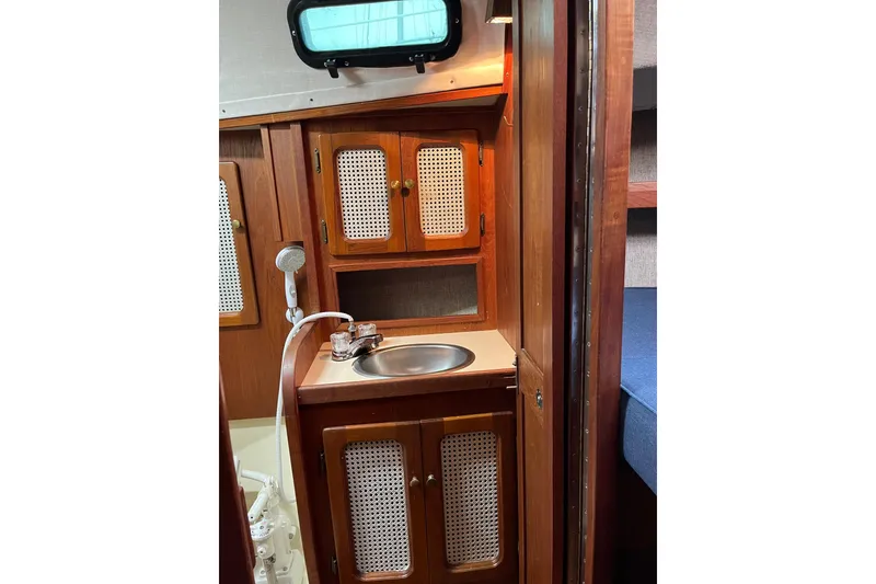 Slide: The Image of 1985 S2 11.0 meter A yacht interior with wooden cabinetry and compact sink. - 27