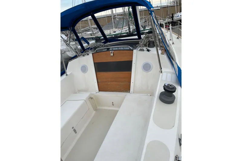 Slide: The Image of 1985 S2 11.0 meter A sailboat cockpit with blue canopy and wooden accents. - 37