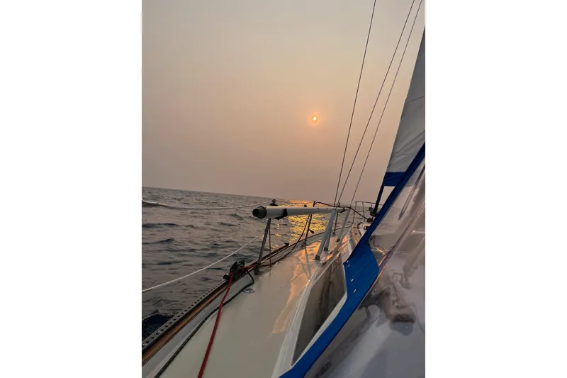 Slide: The Image of Sailing on 1985 S2 11.0 meter A yacht at sunset over calm ocean waters. - 40