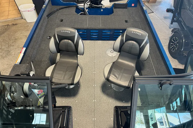 Slide: The Image of 2026 Lund 1650 Angler Sport boat interior with two cushioned seats and steering console. - 3