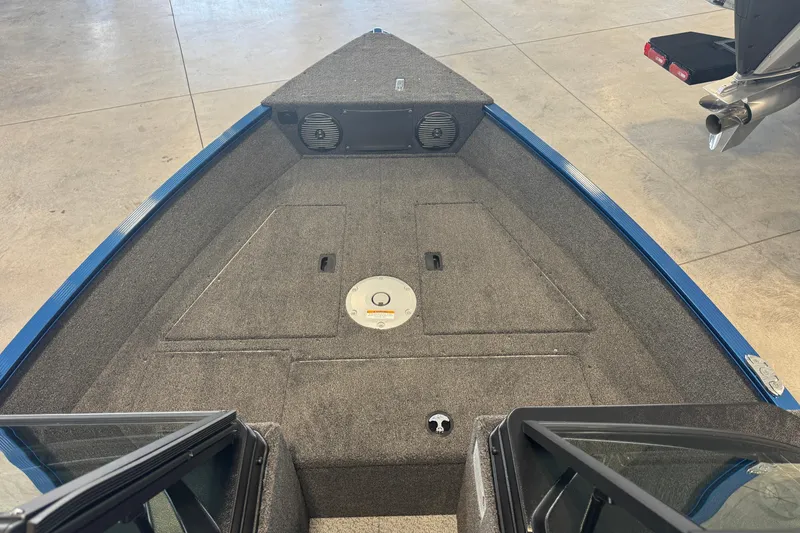 Slide: The Image of 2026 Lund 1650 Angler Sport boat interior with carpeted deck and storage compartments. - 5
