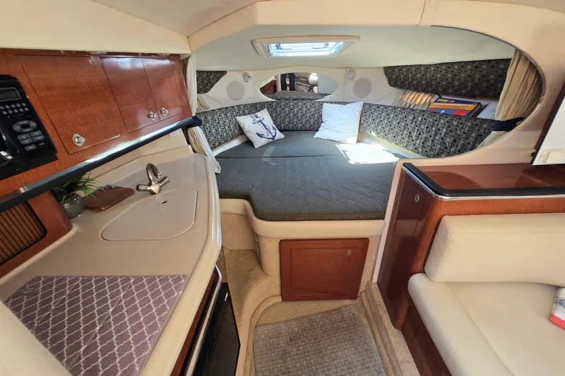 Slide: The Image of 2005 Sea Ray 290 Amberjack cabin interior with cozy seating and kitchenette. - 1