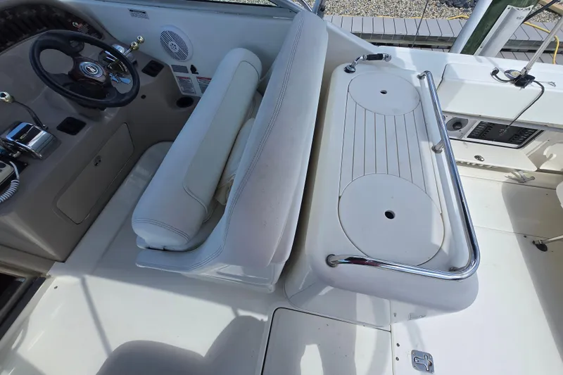 Slide: The Image of 2005 Sea Ray 290 Amberjack helm with steering wheel, controls, and seating area. - 12