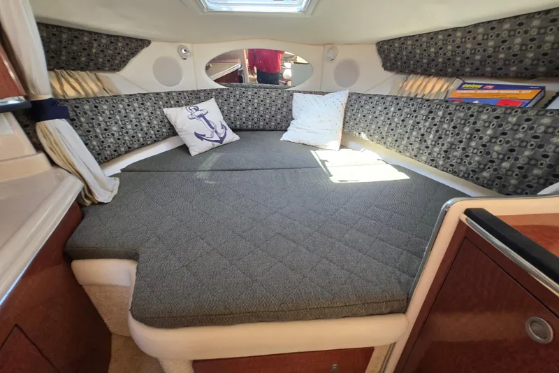 Slide: The Image of Cozy cabin interior of 2005 Sea Ray 290 Amberjack with patterned cushions and pillows. - 13