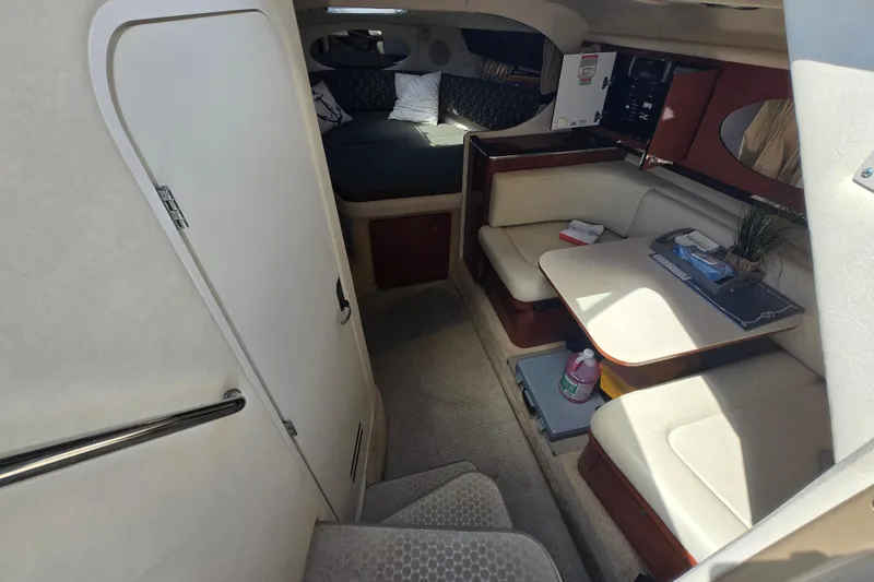 Slide: The Image of Interior of 2005 Sea Ray 290 Amberjack, featuring cozy seating and a compact dining area. - 14