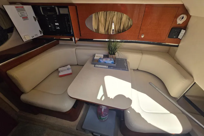 Slide: The Image of 2005 Sea Ray 290 Amberjack cabin interior with beige seating and wooden cabinetry. - 15
