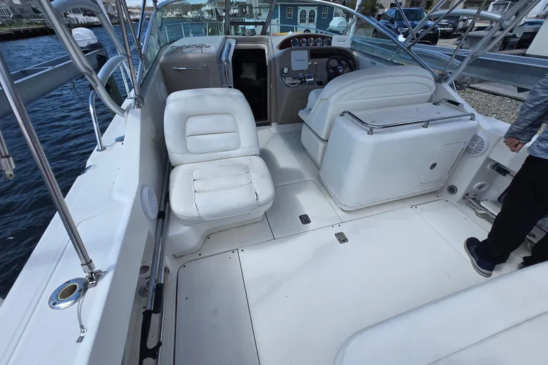 Slide: The Image of 2005 Sea Ray 290 Amberjack boat interior with white seating and steering console. - 2