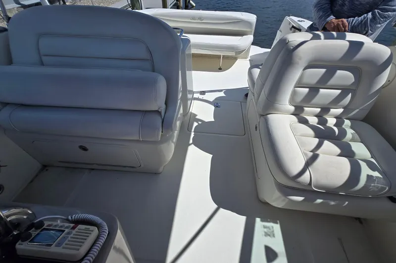 Slide: The Image of 2005 Sea Ray 290 Amberjack boat interior with white cushioned seating and control panel. - 22