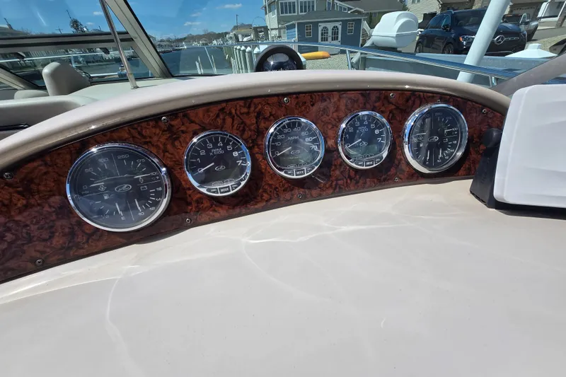 Slide: The Image of Dashboard of 2005 Sea Ray 290 Amberjack with five gauges and wood paneling. - 30