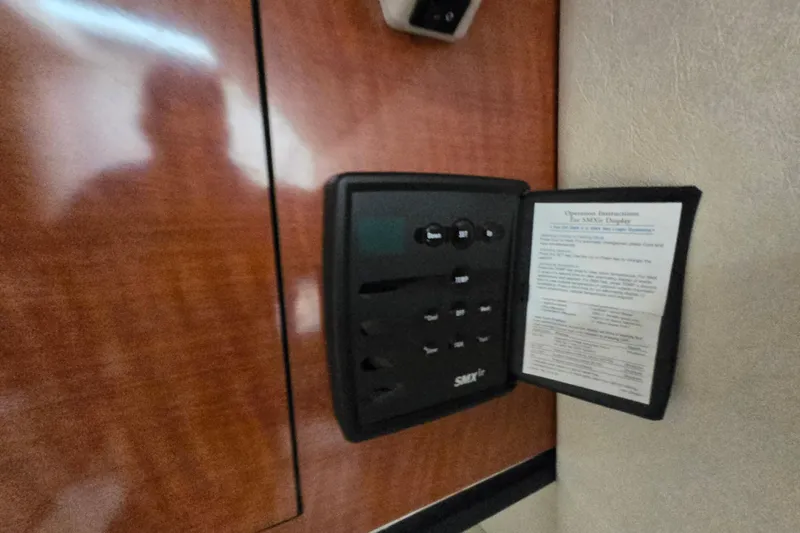 Slide: The Image of Control panel inside 2005 Sea Ray 290 Amberjack boat cabin with instruction manual. - 31
