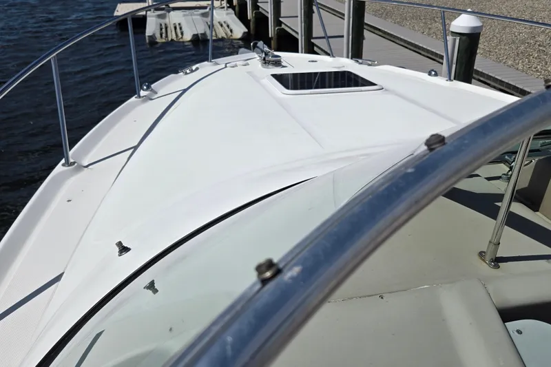Slide: The Image of 2005 Sea Ray 290 Amberjack boat deck with railing, docked by the water. - 32