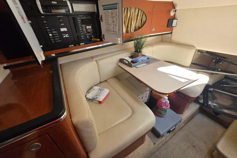 Slide: The Image of 2005 Sea Ray 290 Amberjack cabin interior with seating, table, and control panel. - 5