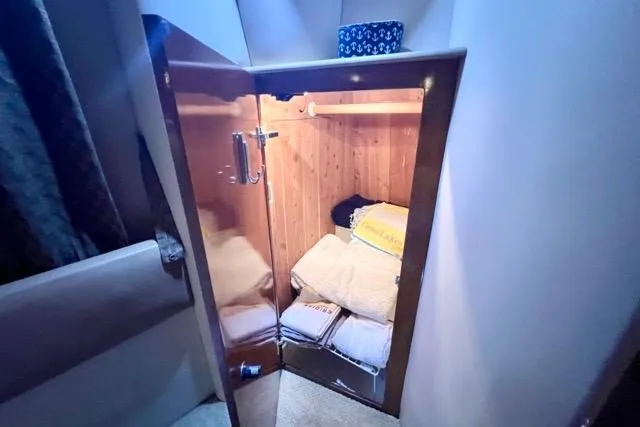 Slide: The Image of 2007 Meridian 368 Motoryacht interior closet with wooden finish and neatly stacked towels. - 25