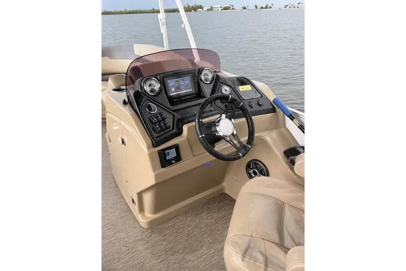 Slide: The Image of 2021 Sylvan L1 SPX boat dashboard with steering wheel and control panel on water. - 11