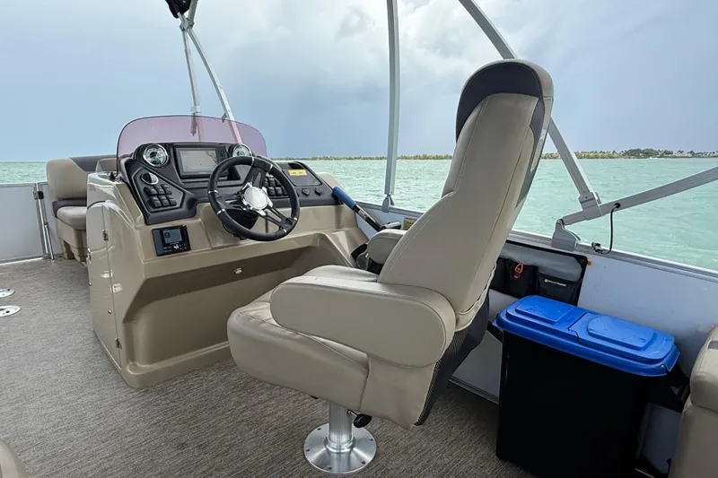 Slide: The Image of 2021 Sylvan L1 SPX boat interior with steering console and comfortable seating on open water. - 13