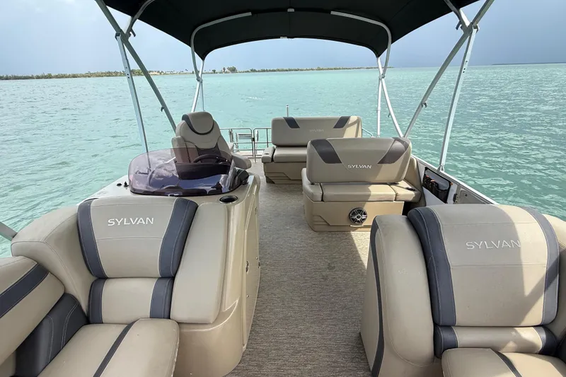 Slide: The Image of 2021 Sylvan L1 SPX pontoon boat interior on calm turquoise water. - 16