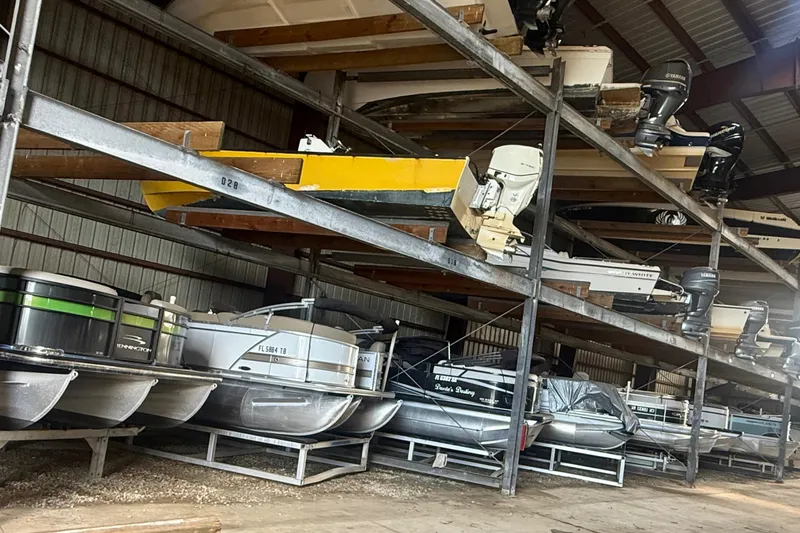 Slide: The Image of Indoor boat storage with various boats, including a 2021 Sylvan L1 SPX, on metal racks. - 21