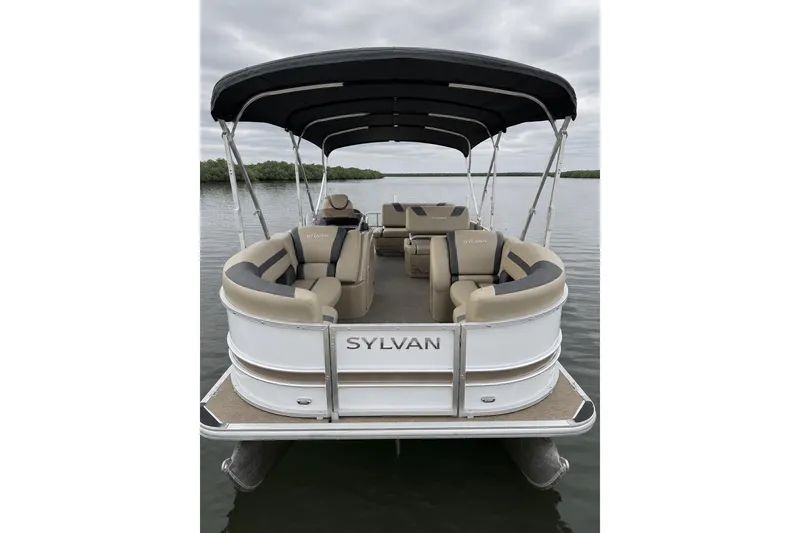 Slide: The Image of 2021 Sylvan L1 SPX pontoon boat on calm water, featuring spacious seating and canopy. - 8