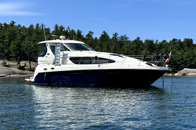The Image of 2006 Sea Ray 40 Motor Yacht on calm water near forest. - 0