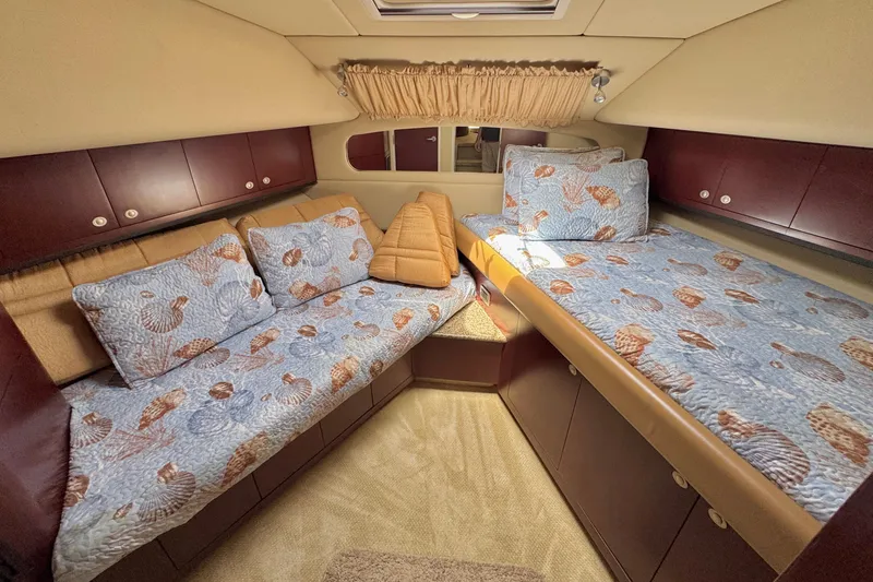 Slide: The Image of 2006 Sea Ray 40 Motor Yacht cabin with seashell-themed bedding and wooden cabinetry. - 34