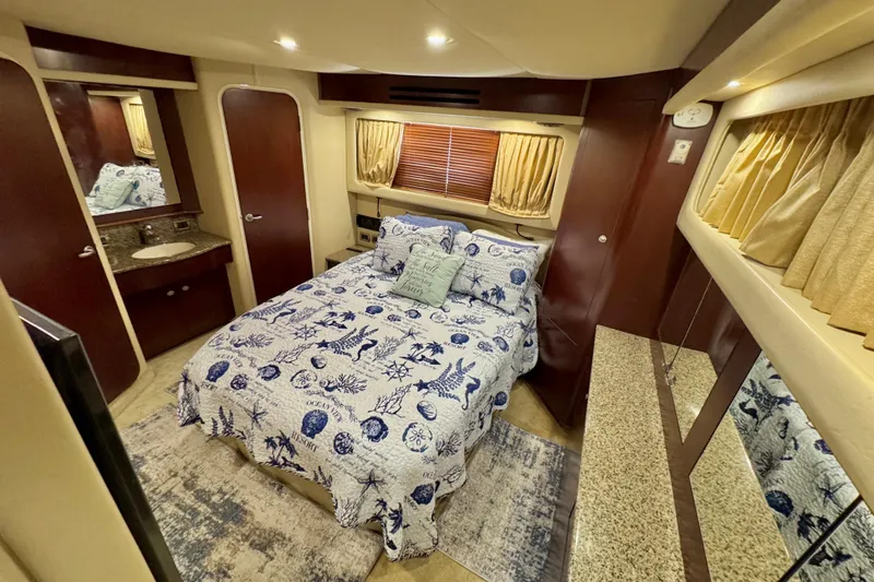 Slide: The Image of Luxurious 2006 Sea Ray 40 Motor Yacht bedroom with nautical-themed bedding and elegant wood finishes. - 52