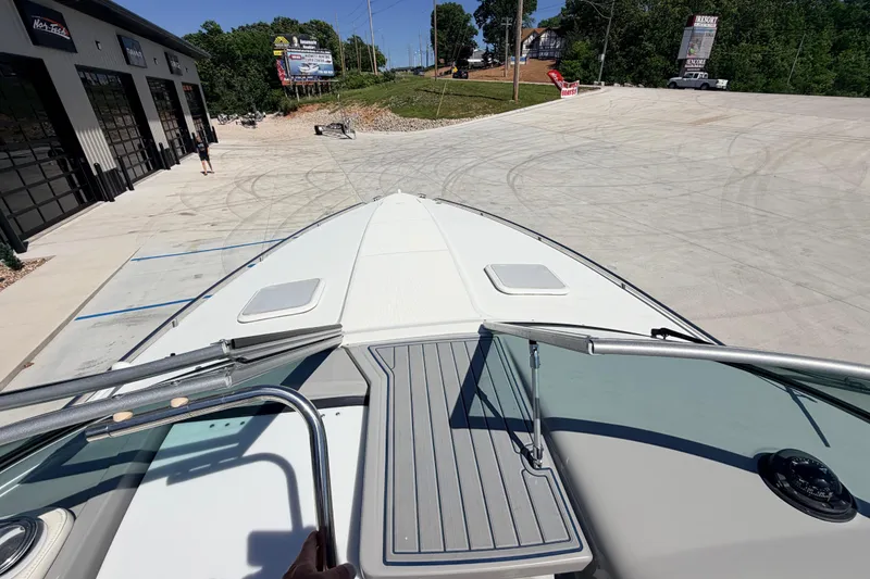 Slide: The Image of 2002 Formula 330 Sun Sport boat on a concrete lot, surrounded by greenery and buildings. - 22