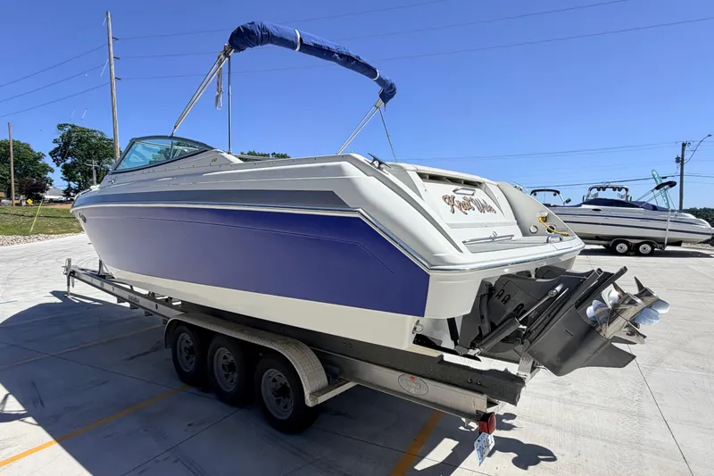 Slide: The Image of 2002 Formula 330 Sun Sport boat on trailer, blue and white design, parked outdoors. - 4