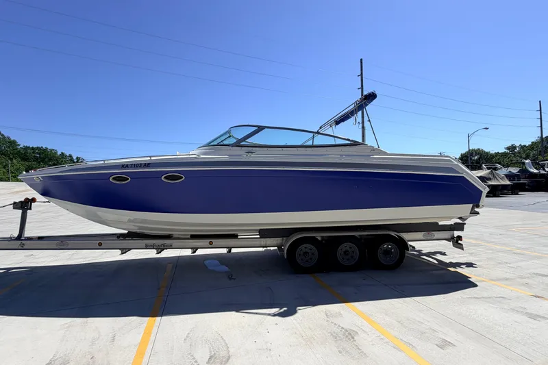 Slide: The Image of 2002 Formula 330 Sun Sport boat on trailer in parking lot under clear blue sky. - 5