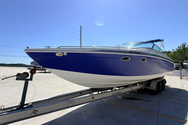 Slide: The Image of 2002 Formula 330 Sun Sport boat on trailer, blue and white design, sunny day. - 6