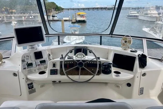 Slide: The Image of 2003 Silverton 43 Motor Yacht helm with navigation equipment, overlooking marina and waterway. - 10